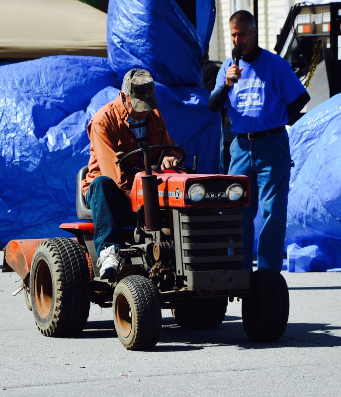 man on small red tractor